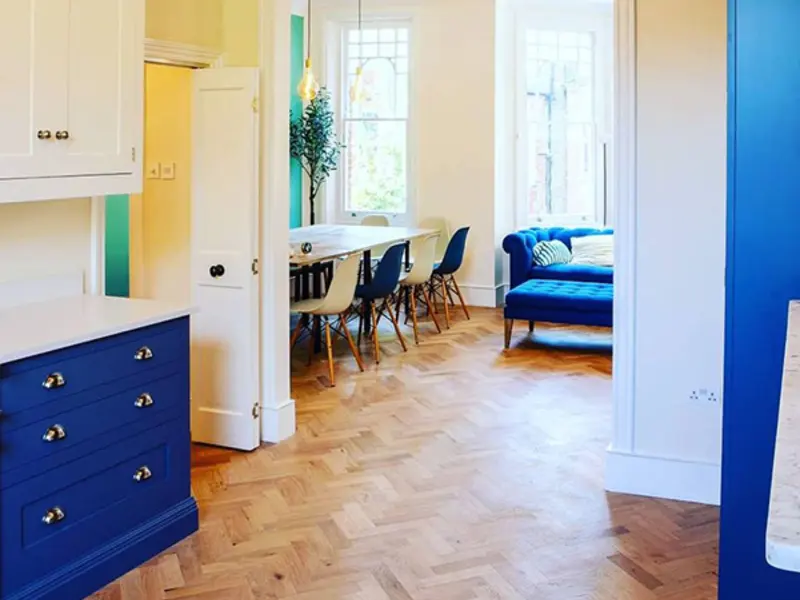 Navy kitchen with parquet flooring and open dining space