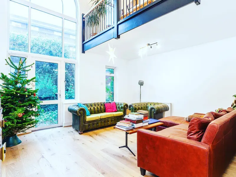 Double-height living space with mezzanine and arched window